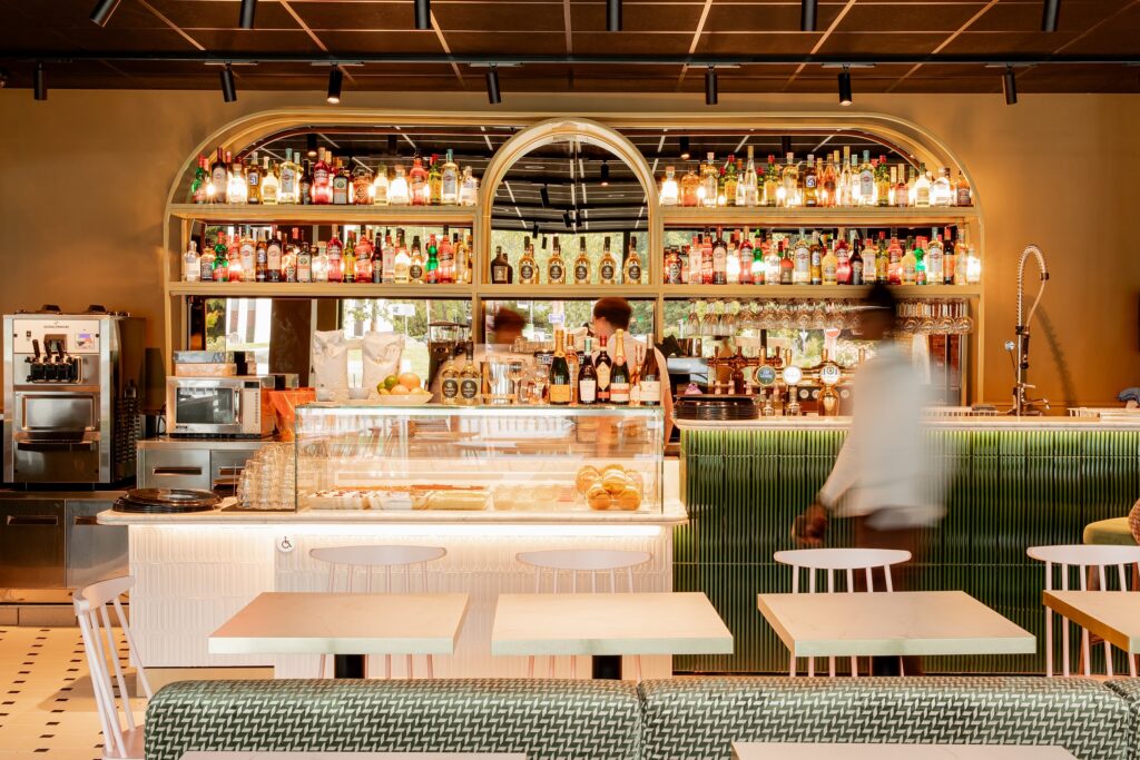 Le bar d'Italian Queen Meylan sous son arche lumineuse, la vitrine à dolci et le comptoir vert