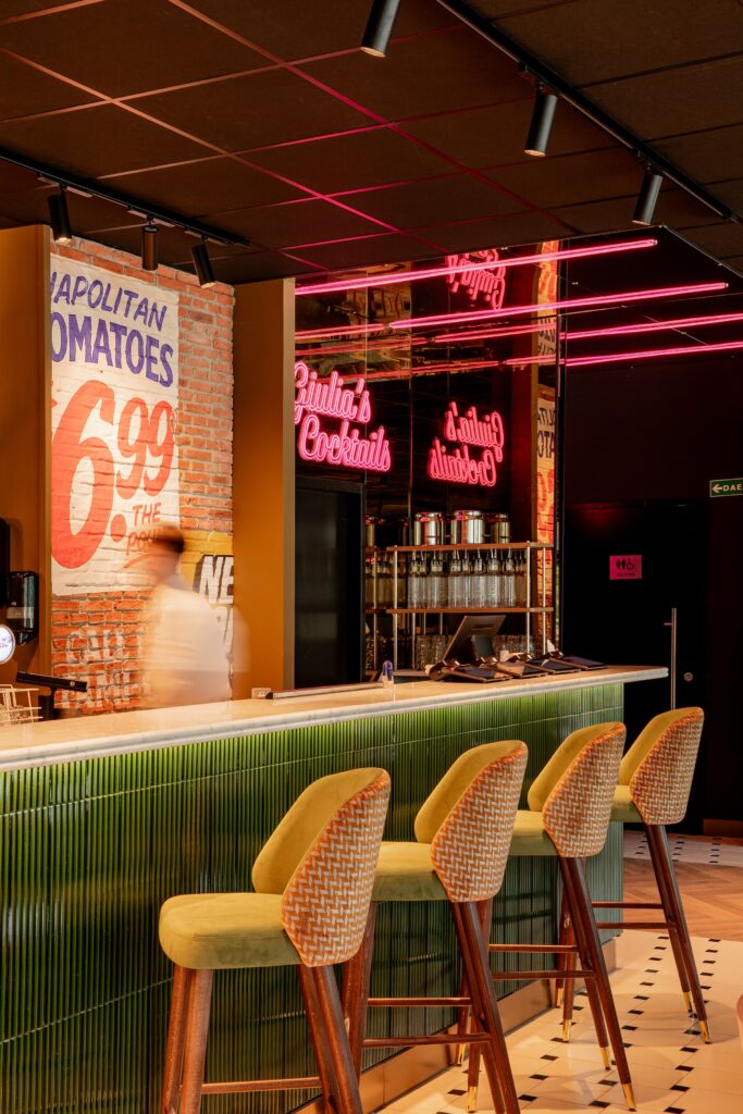 Le bar d'Italian Queen Meylan, ses néons roses, l'affiche « Napolitan Tomatoes » et les tabourets